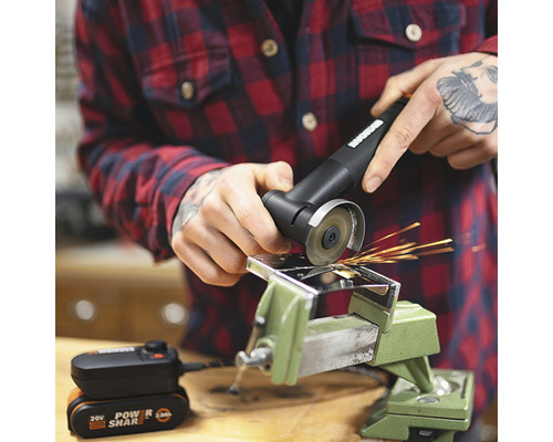 Accu-aangedreven haakse slijper in gebruik met bankschroef en metalen stuk