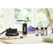 Worx Logo op airbrushset met batterij en kleuren op een tafel