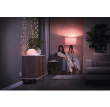 Woonkamer met verlichting, commode, bank en vrouw