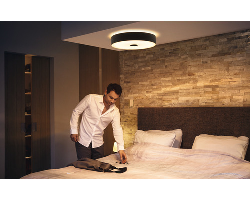 Man in slaapkamer onder ronde plafondlamp