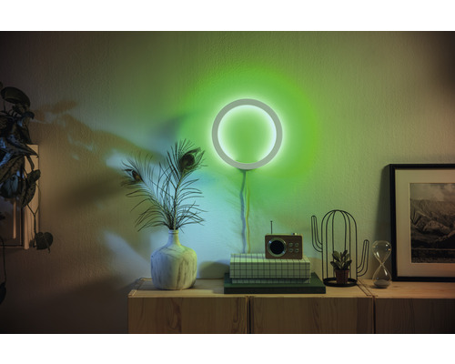 Woonkamer met cirkelvormige wandlamp, decoratie en houten dressoir