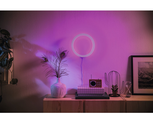 Decoratieve scène met cirkelvormige lamp, vintage radio, zandloper en planten op een houten kast