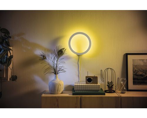 Woonkamer met ronde wandlamp en decoratie op een dressoir