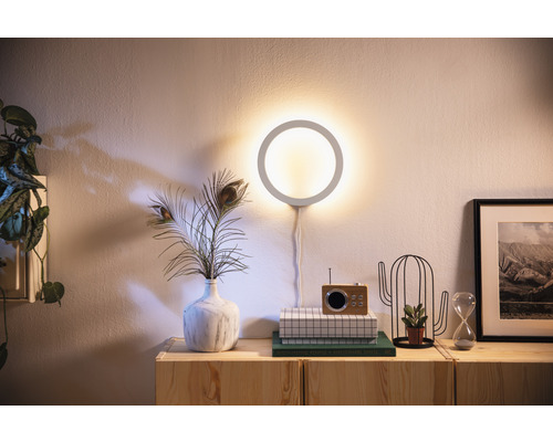 Woonkamer met ronde wandlamp, decoratie en houten dressoir
