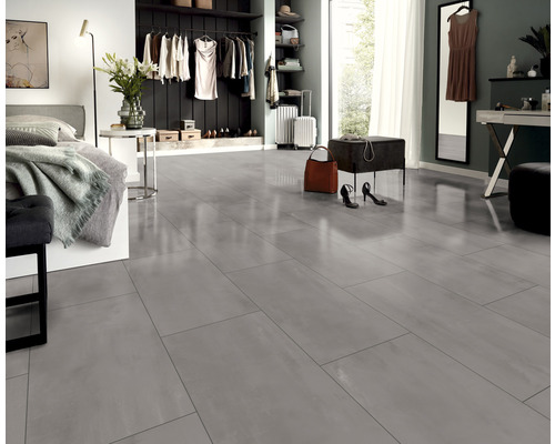 Lichte slaapkamer met grijze vloertegels, bed, kledingkast en accessoires