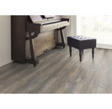 Interieur met laminaatvloer, piano en kruk