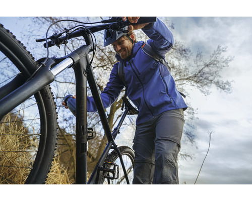 Man duwt een zwarte mountainbike de heuvel op