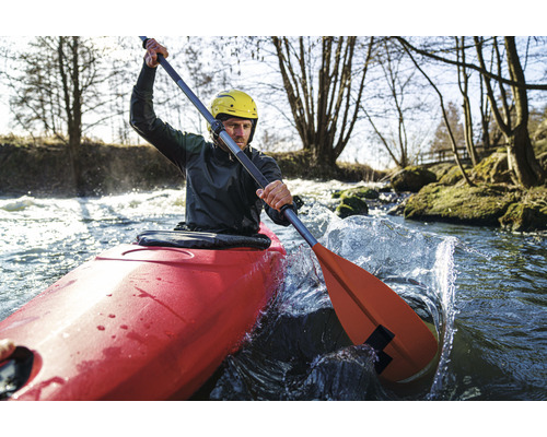 Man in kajak op een rivier met peddel en helm