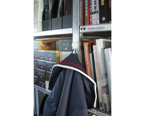 Jas hangt aan een haak in een boekenrek met boeken en mappen.