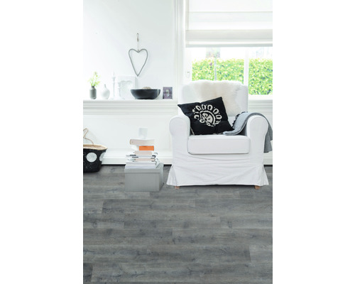 Lichte woonkamer met grijze laminaatvloer, fauteuil en decoraties