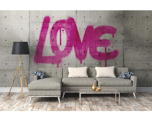 Woonkamer met bank, staande lamp en muurschildering met het woord liefde.