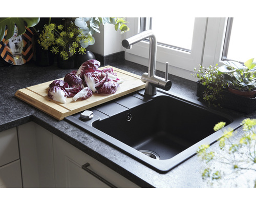 Spoelbak met kraan, snijplank en rode sla op het aanrecht