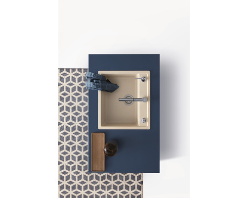 Bovenaanzicht van een spoelbak met kraan, afwasmiddel, opbergbak en theedoek op een wastafel