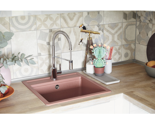 Keukenspoelbak met kraan en decoratieve elementen op een werkblad.