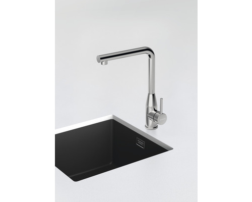 Metalen gootsteenkraan naast spoelbak