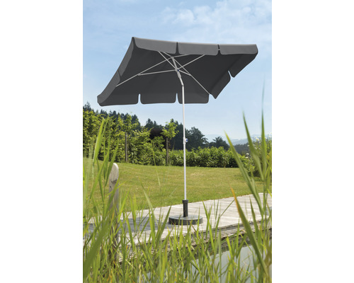 Vierkante parasol met voet in de tuin.