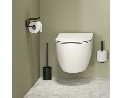 Wandcloset met toiletpapierhouder en toiletborstel in een badkamer.