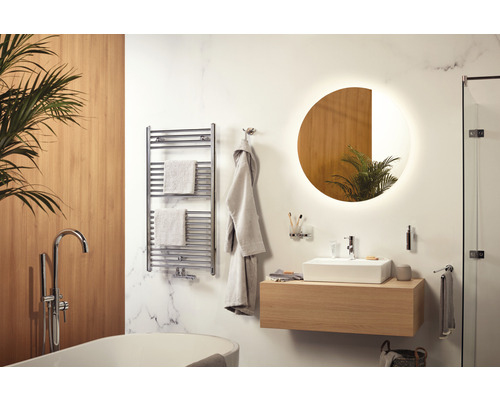 Moderne badkamer met ligbad, wastafel, spiegel en radiator