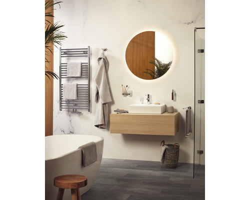 Badkamer met bad, wastafel, spiegel en handdoekradiator