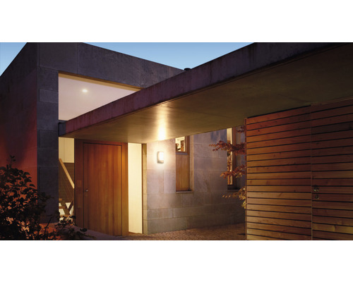 Buitenaanzicht van een modern huis met deur en buitenlamp.