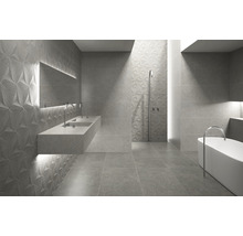 Moderne badkamer met driedimensionale tegels, wastafel en bad.