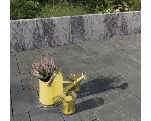 Tuinontwerp met bestrating, muur, gieter en kaarsen