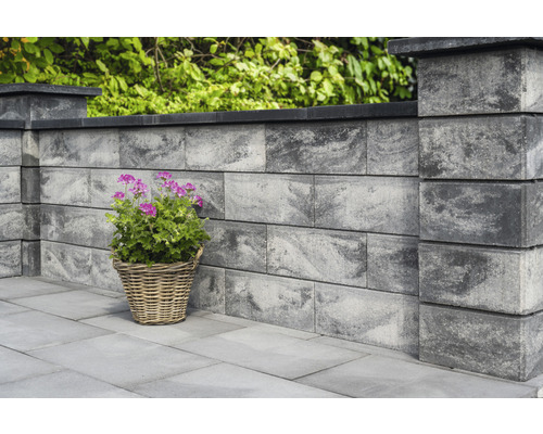 Muur van betonblokken met plant in mand