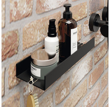 Zwarte wandplank in de badkamer met cosmetische producten op bakstenen muur
