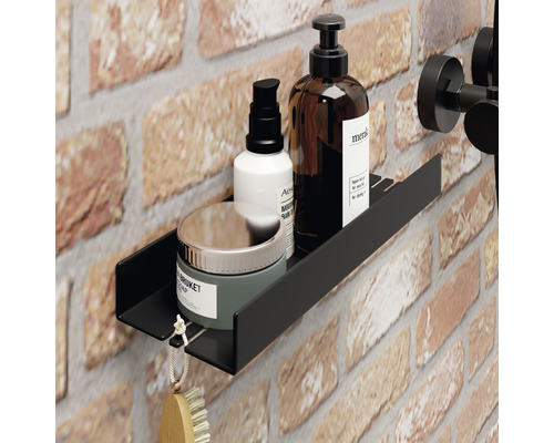 Zwarte wandplank in de badkamer met cosmetische producten op bakstenen muur