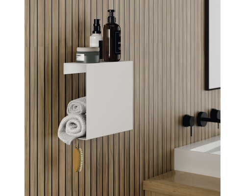 Badkamerscène met wit wandrek, handdoeken en verzorgingsproducten.