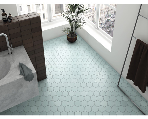 Lichte badkamer met zeshoekige vloertegels, wastafel, handdoek en kamerplant