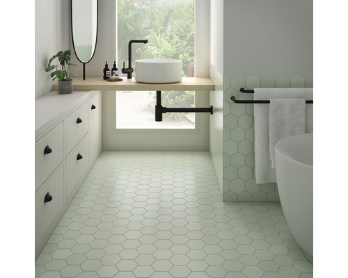 Badkamer met zeshoekige tegels, wastafel, spiegel en bad voor een heldere en georganiseerde sfeer.