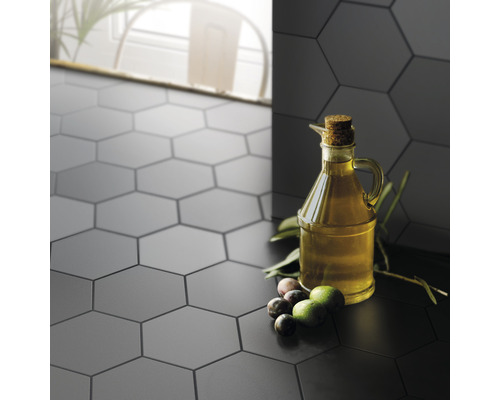 Zeshoekige tegels op wand en vloer met olijven en een oliekan