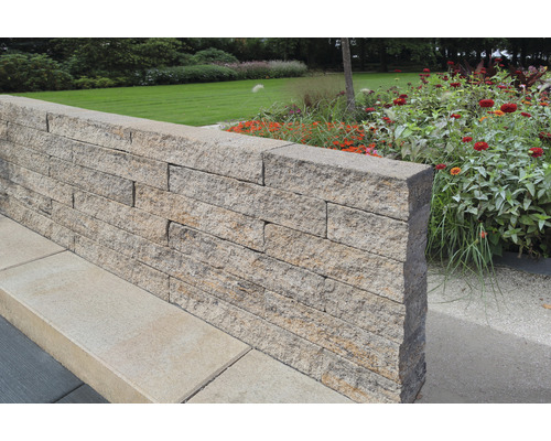 Tuinmuur gemaakt van natuurstenen blokken in de buitenruimte