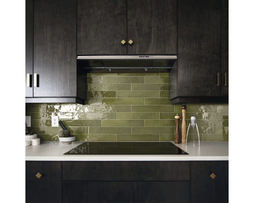 Keukenscène met afzuigkap, groene wandtegels en keukengerei op het aanrecht