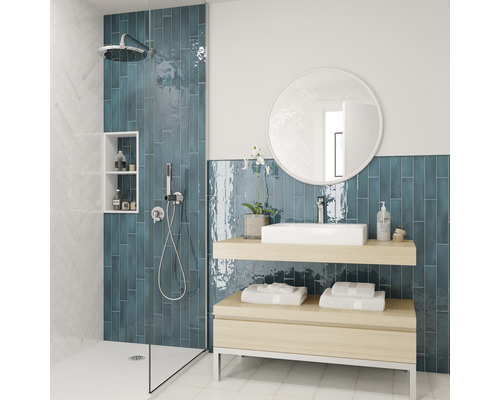 Lichte badkamer met douche, wastafel en blauwe tegels