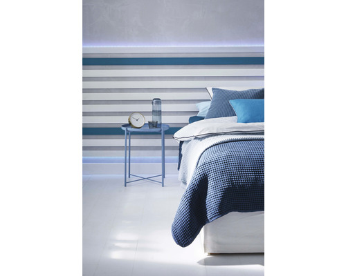 Slaapkamer met bed, nachtkastje en decoratieve wandbekleding