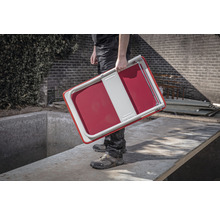 Een persoon draagt een opklapbaar krukje.