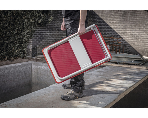 Een persoon draagt een opklapbaar krukje.