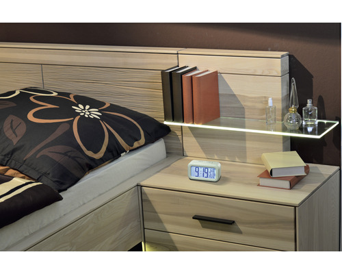 Bed met nachtkastje, boeken, wekker en decoratieve items