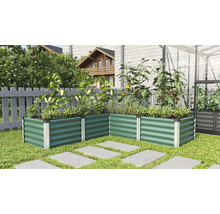 Metalen verhoogde tuinbak in de tuin met planten en tegels