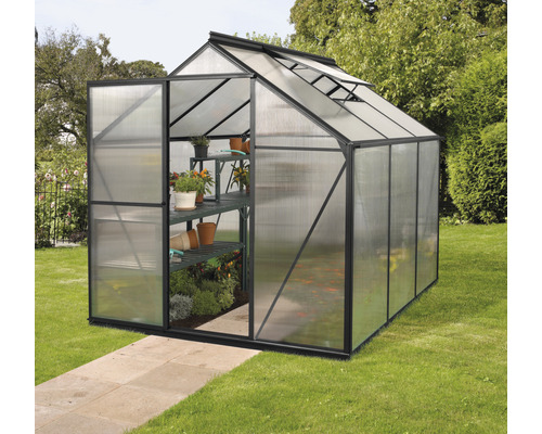 Kas met open deur en rekken voor planten op gazon