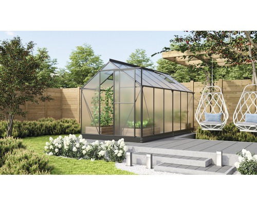 Kas in de tuin met planten, zitplaatsen en gazon