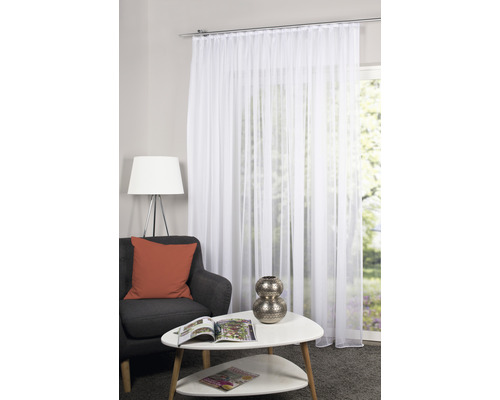 Woonkamer met witte, transparante voile gordijnen voor een raam