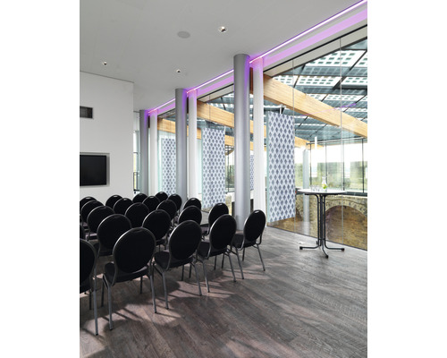 Lichte vergaderruimte met stoelen, groot raam en houten vloer