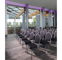 Interieur met rijen stoelen, houten vloer en raampartij