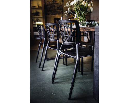 Zwarte stoel met open rugleuning bij een eettafel