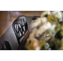 Zwarte kunststof stoel met houten tafel en bloemendecoratie