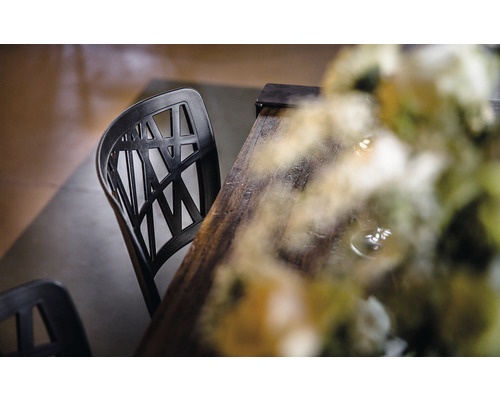 Zwarte kunststof stoel met houten tafel en bloemendecoratie