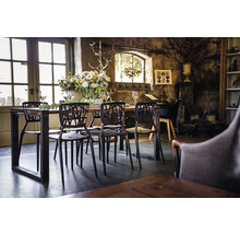 Eettafel met stoelen in een lichte ruimte met rustieke inrichting en bloemen